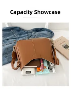 Internal capacity display of large brown crossbody bag showing books and cosmetics