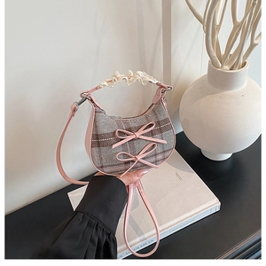 Detail of checkered plaid mini bag with pink bows and lace-wrapped top handle