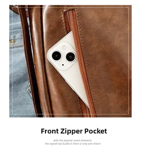 Détail de la poche zippée avant du sac fourre-tout en cuir marron avec un smartphone