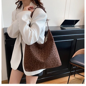 Brown leopard print bucket bag styled on a white blazer, showing fashion underarm carry