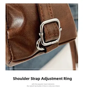 Détail de la boucle de sangle réglable argentée sur un sac cabas en cuir marron