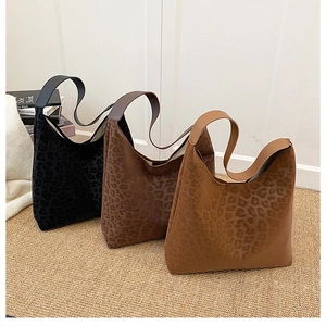 Macro detail of large leopard print hobo tote bags in three colors with soft suede texture