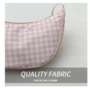 Detailed close-up of pink plaid dumpling bag fabric with colorful star patterns
