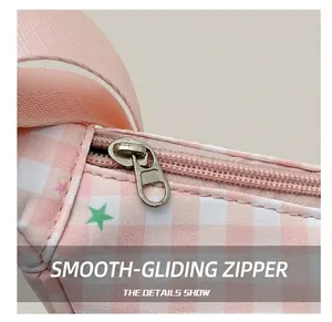 Detail shot of smooth silver zipper on pink plaid fabric with star prints