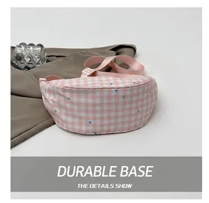 Close-up of pink checkered canvas waist bag with star patterns and durable bottom detail