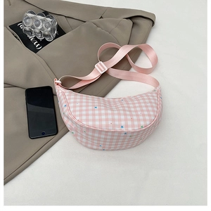 Dettaglio borsa a mezzaluna a scacchi rosa con stelle, cinturino e fibbia bianca