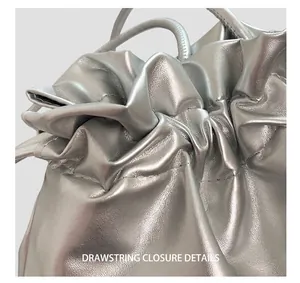 Detail of silver metallic bucket bag showing drawstring closure and stitching