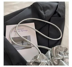 Close-up of silver-grey pleated drawstring bucket bag with soft PU leather texture
