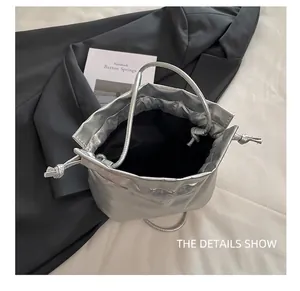 Detailed interior view of silver drawstring bucket bag with spacious black fabric lining