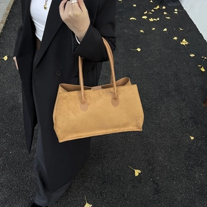 Sac cabas minimaliste en daim marron pour femme avec une tenue de mode automnale