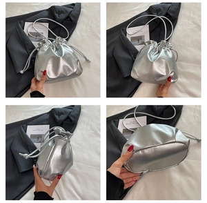 Macro shot of stylish silver metallic drawstring bucket bag with shiny faux leather texture