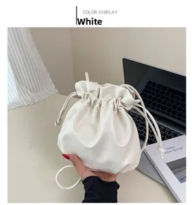 Detail of white mini drawstring bucket bag with soft PU leather and fine texture