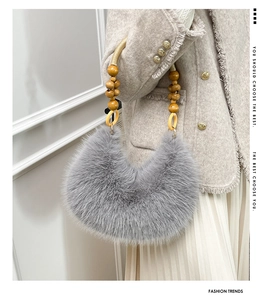 Détail du sac à main gris en peluche avec poignée en perles de bois et anneaux jaunes
