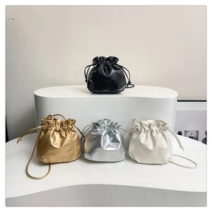 Mini drawstring bucket bags in black, gold, silver, and cream with cloud pleats
