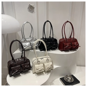 Showcase of patent leather shoulder bags in five colors with cute bow pocket details