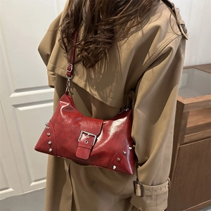 Retro red glossy tote bag with silver rivets and metal buckle worn with trench coat