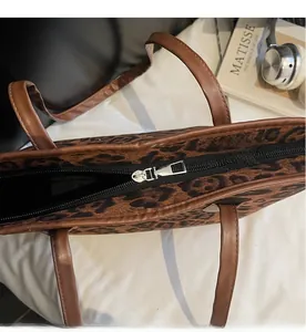 Close-up of smooth metal zipper closure on the vintage leopard print tote bag