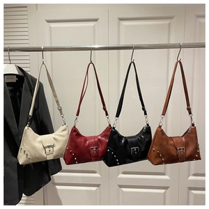 Detailed row of vintage rivet tote bags in cream, red, black, and brown hanging on a rack