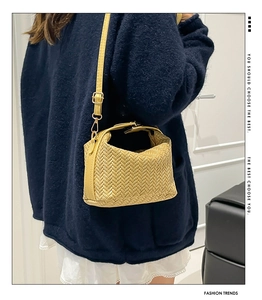 Detail of bright yellow woven leather shoulder bag showing intricate herringbone pattern