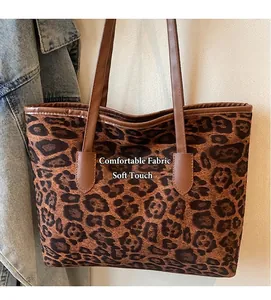 Detail of leopard print tote bag with soft fabric texture and brown leather straps
