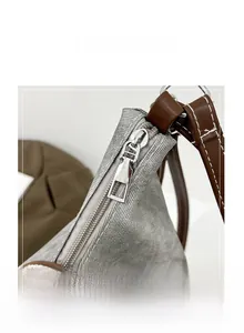 Close-up of durable gray fabric texture with brown leather strap and smooth metal zipper