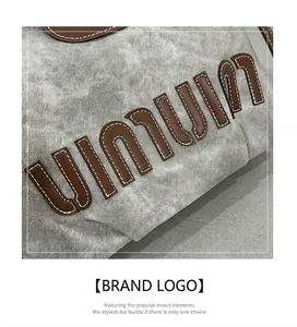 Detail of vintage gray washed fabric backpack with brown leather UINUIN letter patch