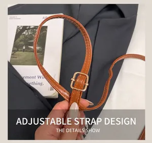 Detail of brown PU leather shoulder strap with adjustable gold buckle for bucket bags