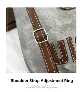 Detail showing adjustable brown leather strap with silver metal buckle on grey tote bag