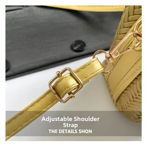 Detail of adjustable yellow leather shoulder strap with golden metal hardware on woven bag