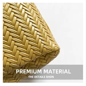 Macro view of bright yellow woven leather bag showing precise stitch texture and base structure