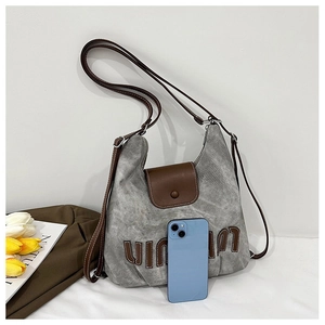 Detail of grey canvas tote bag showing interior capacity and leather strap details
