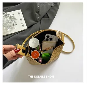 Top view of yellow woven handbag showing large capacity with phone and cosmetics