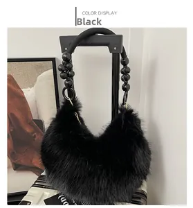 Détail du sac hobo en fausse fourrure noire avec poignée en perles et texture douce