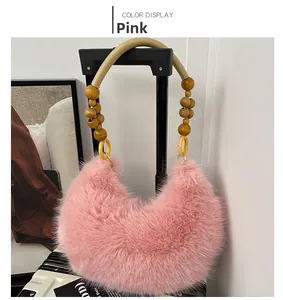 Détail du sac à bandoulière en peluche rose avec poignée en perles de bois et anneaux jaunes