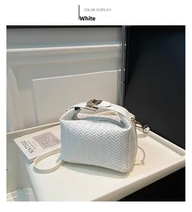 Close-up of white woven leather dumpling bag with elegant gold metal buckle detail