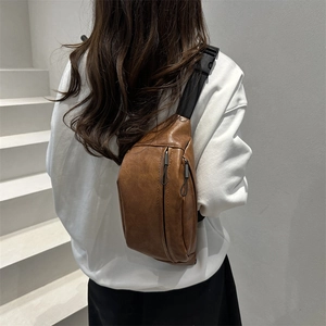 Retro brown leather waist bag with zipper pocket shown on model in a white staircase setting