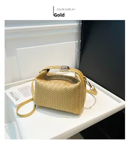 Close-up of golden woven crossbody bag with herringbone texture and metallic buckle