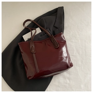 Detail view of burgundy glossy tote bag with reinforced stitching on high-shine finish