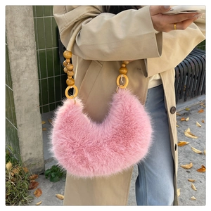 Détail du sac à bandoulière en fausse fourrure rose avec poignée artisanale en perles de bois