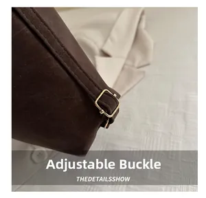 Detail of coffee brown matte leather bag with adjustable light gold metal buckle hardware