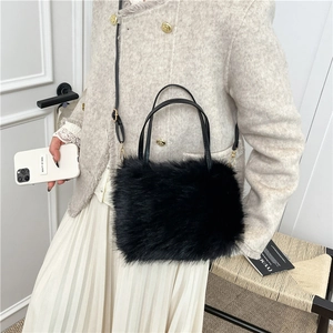 Elegant black faux fur handbag with shoulder strap worn over a stylish white tweed jacket