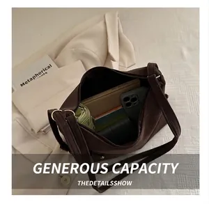 Spacious interior of a dark brown retro tote bag showing phone, umbrella, and notebook