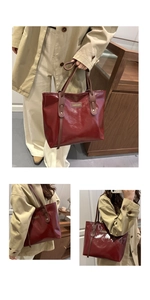 Detail of burgundy patent leather tote bag showing gold logo and brown shoulder straps