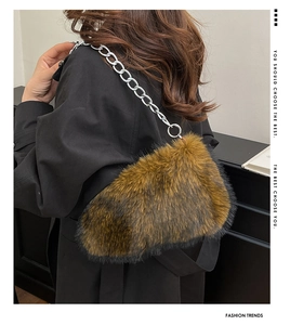 Detail of plush faux fur shoulder bag with silver metal chain strap and fluffy texture