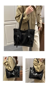 Close-up of a glossy black patent leather tote bag with a golden metal logo plaque