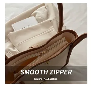 Detail of a beige shoulder bag featuring smooth zipper and magnetic closure system