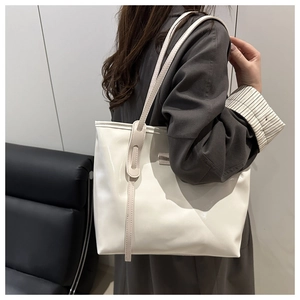 Gros plan sur un sac cabas blanc brillant avec étiquette Fashion sur un canapé en cuir