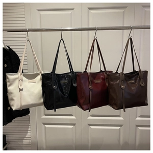 Detailed lineup of large glossy tote bags in cream, black, burgundy, and brown