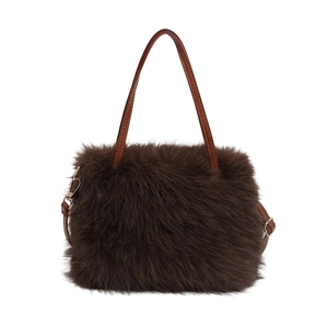 Brown faux fur plush handbag with leather handles and gold-tone metal hardware on white background