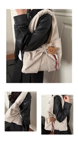 Detailansicht der Cord-Schultertasche mit großer Schleife und kleinem Bärenanhänger
